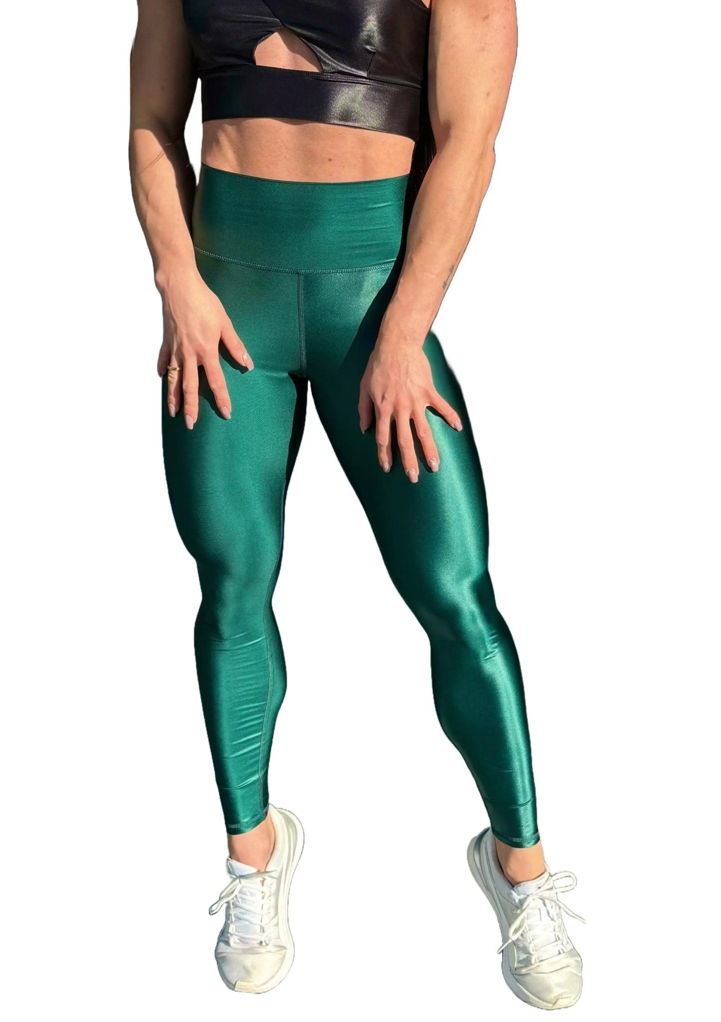 Mujer vistiendo los leggings brillantes de cintura alta Legging Pearl Shine de LUXFEEL en color Verde Botella Brillante, con acabado efecto perla.