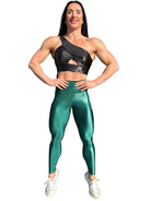 Mujer vistiendo los leggings brillantes de cintura alta Legging Pearl Shine de LUXFEEL en color Verde Botella Brillante, con acabado efecto perla.
