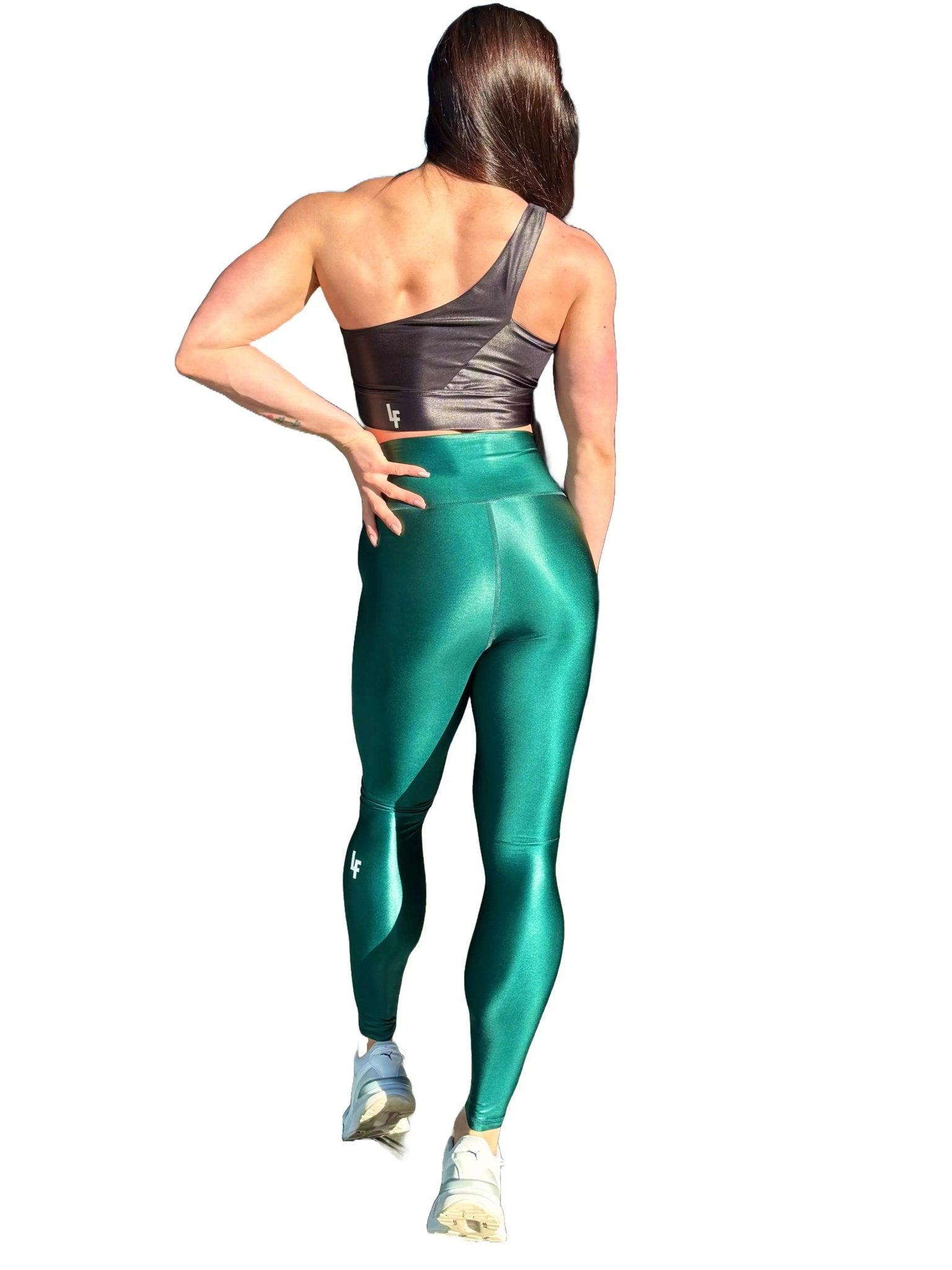 Mujer vistiendo los leggings brillantes de cintura alta Legging Pearl Shine de LUXFEEL en color Verde Botella Brillante, con acabado efecto perla.