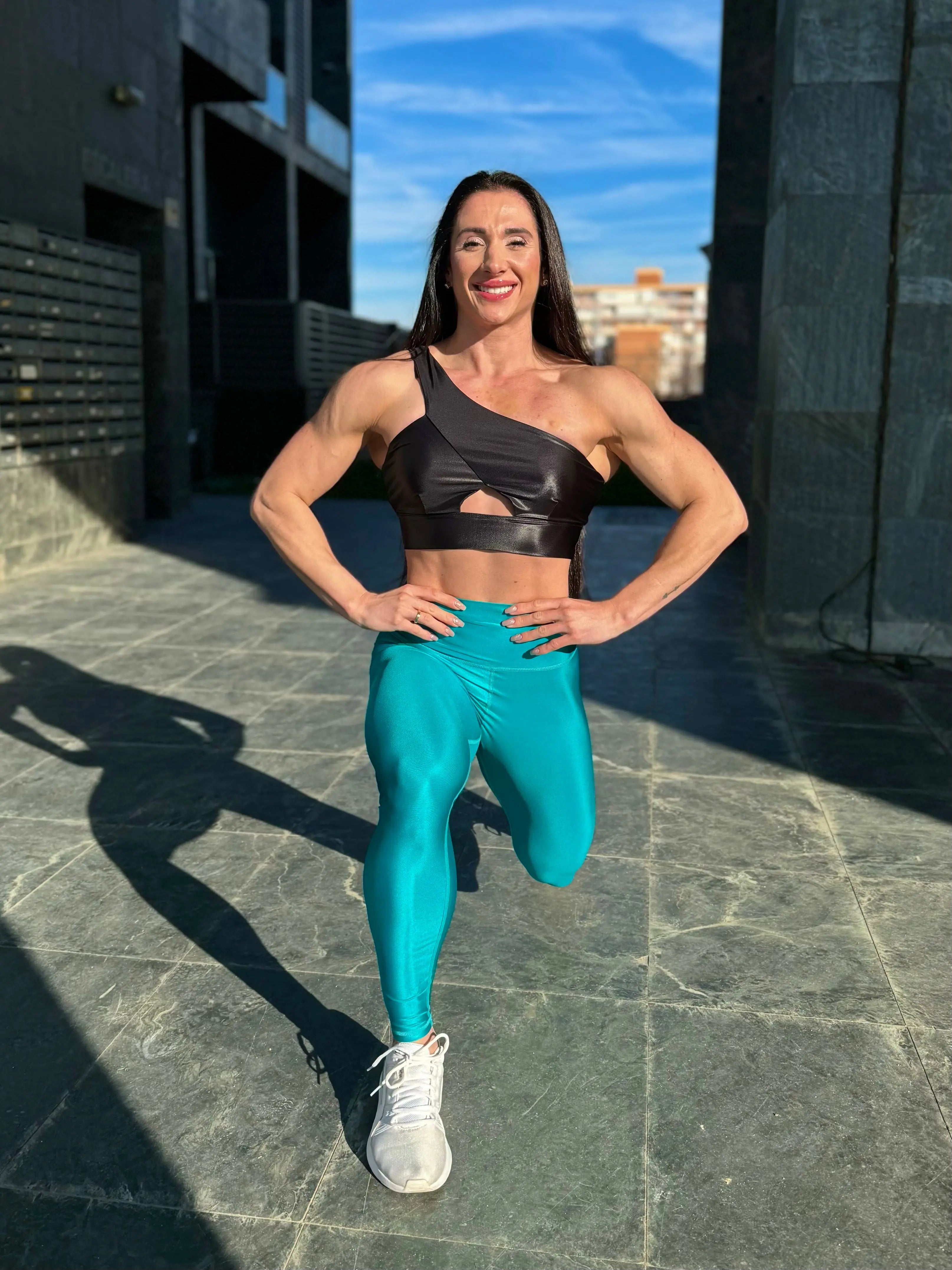 Mujer vistiendo los leggings brillantes de cintura alta Legging Pearl Shine de LUXFEEL en color Azul Capri Brillante, con acabado efecto perla.