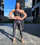 Mujer vistiendo los leggings brillantes de cintura alta Legging Pearl Shine de LUXFEEL en color Negro Brillante, con acabado efecto perla.