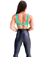Mujer vistiendo los leggings brillantes de cintura alta Legging Pearl Shine de LUXFEEL en color Negro Brillante, con acabado efecto perla.