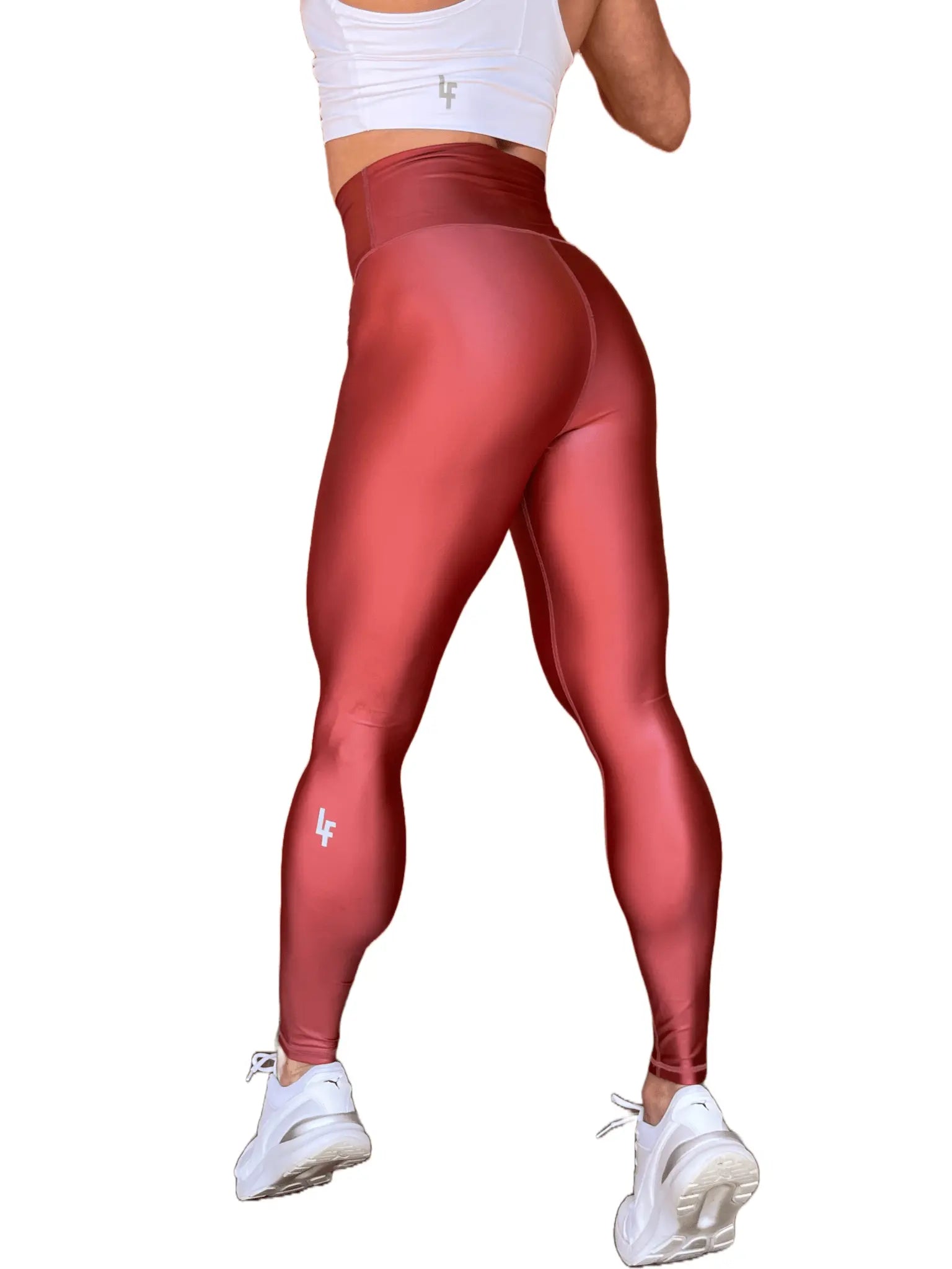 Mujer vistiendo los leggings brillantes de cintura alta Legging Pearl Shine de LUXFEEL en color Teja Brillante / Marron Brillante, con acabado efecto perla.