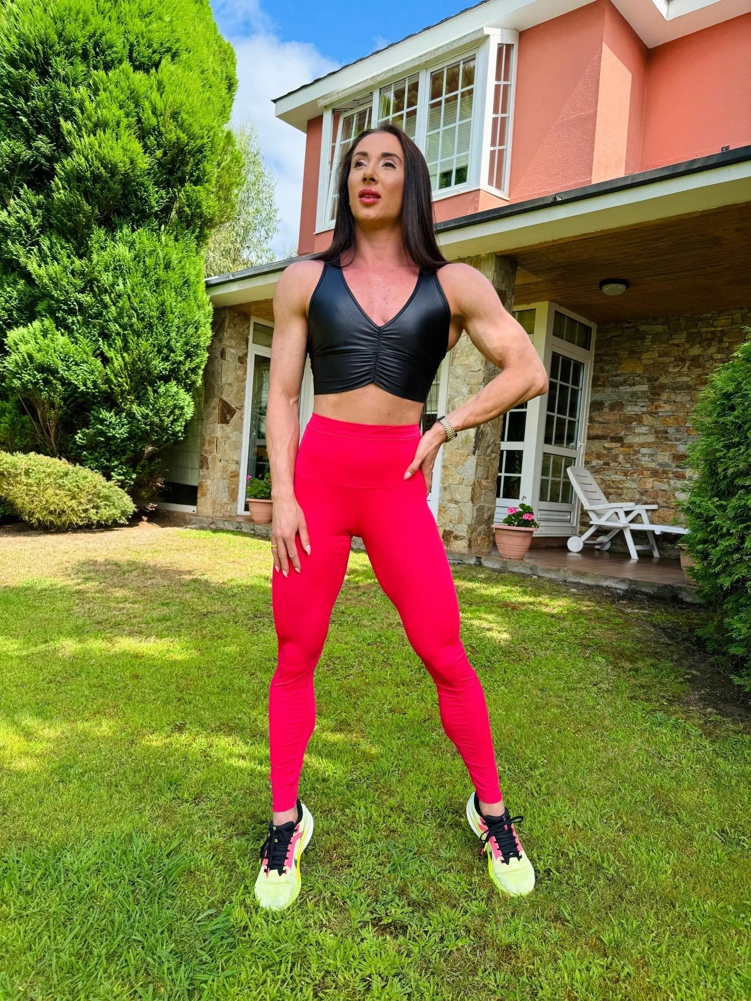 Mujer vistiendo el crop top brillante Top Adela Pearl Shine de LUXFEEL en color Negro Brillante, con escote en V y detalle fruncido en el pecho.