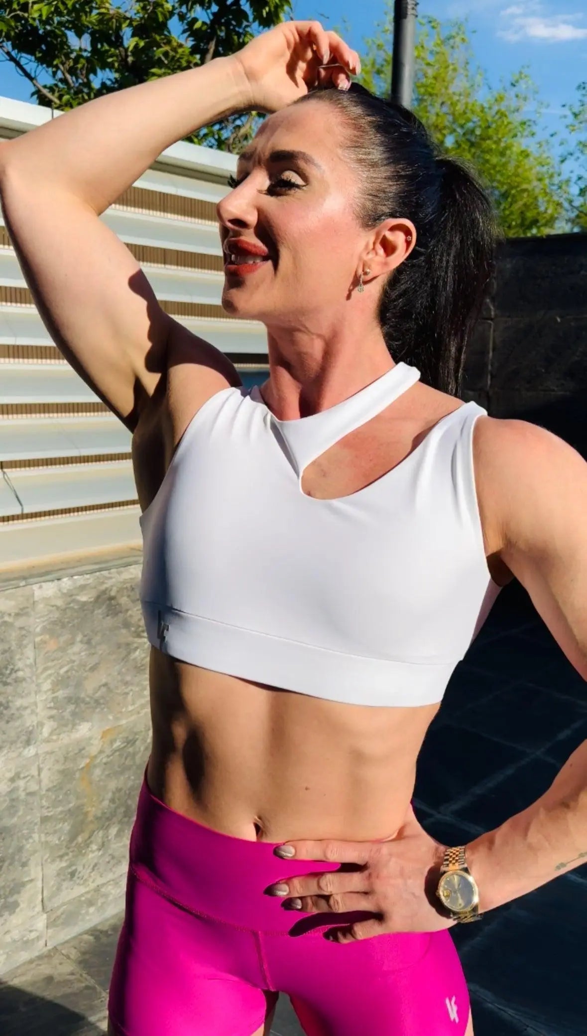 Mujer luciendo el top asimétrico Top Vanesa de LUXFEEL en color Blanco, con un diseño de apertura en el hombro y soporte extra.