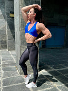 Mujer vistiendo el top deportivo Top Paula de LUXFEEL en color Azul, con sus tirantes convertibles en posición recta para un look clásico.