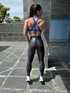 Mujer vistiendo el top deportivo Top Paula de LUXFEEL en color Azul, con sus tirantes convertibles en posición recta para un look clásico.