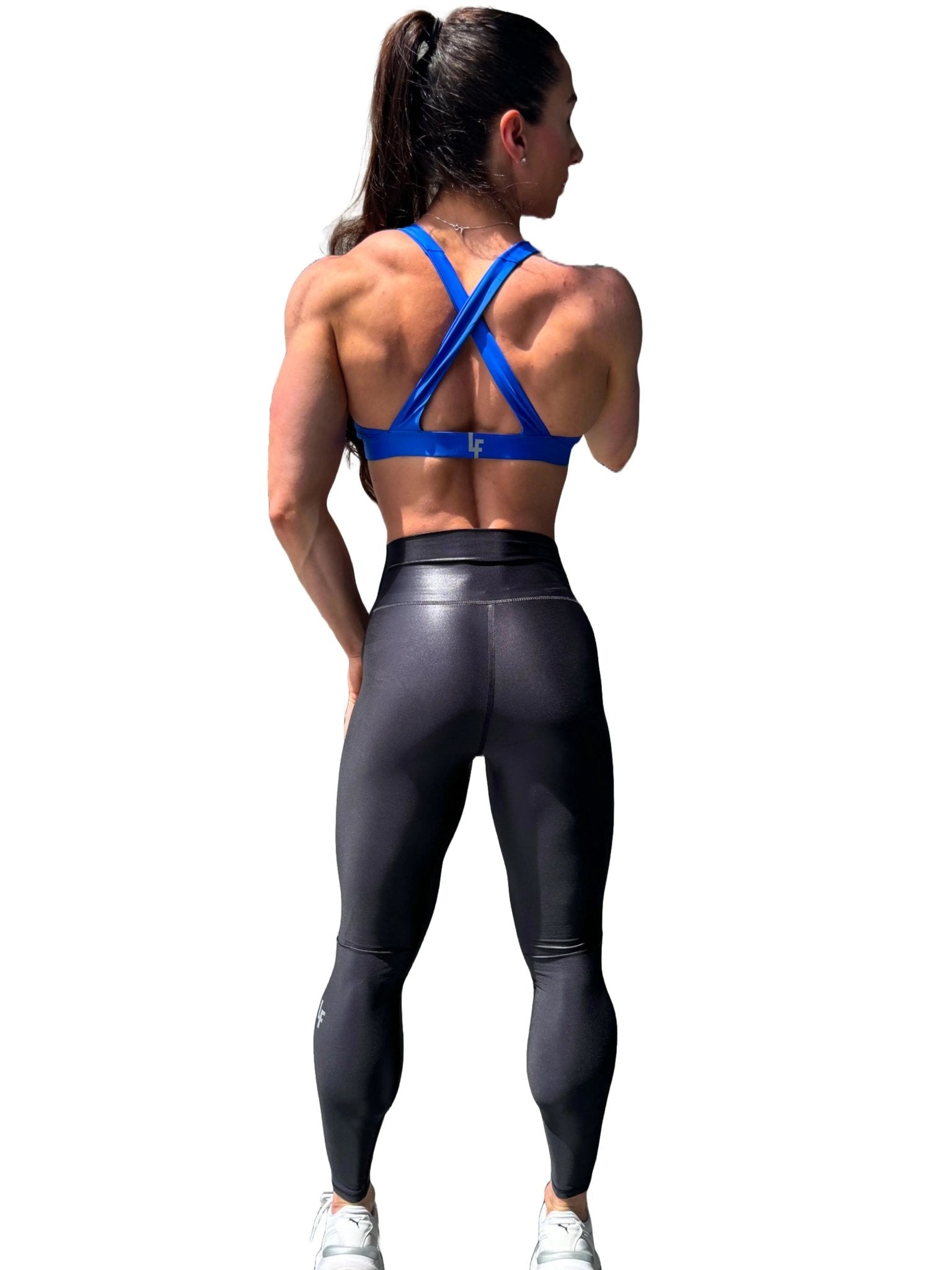 Mujer vistiendo el top deportivo Top Paula de LUXFEEL en color Azul, con sus tirantes convertibles en posición recta para un look clásico.