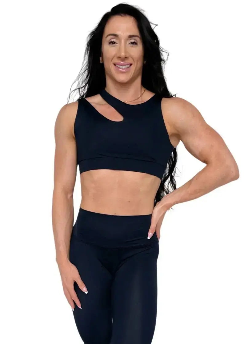 Mujer luciendo el top asimétrico Top Vanesa de LUXFEEL en color Negro, con un diseño de apertura en el hombro y soporte extra.