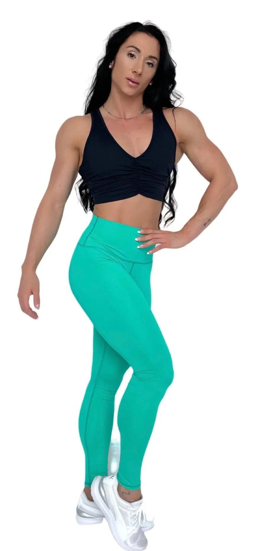 Mujer vistiendo el crop top deportivo Top Adela de LUXFEEL en color Negro, con escote en V y detalle fruncido en el pecho.