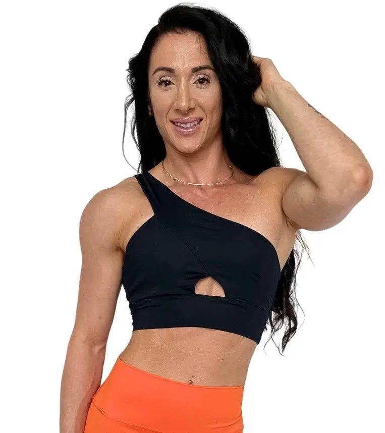 Mujer luciendo el top asimétrico Top Carmela de LUXFEEL en color Negro, con diseño de un solo hombro y apertura en el escote