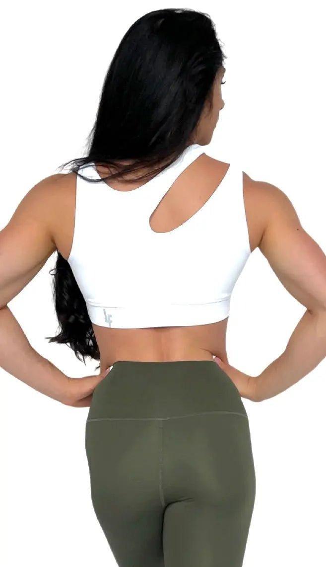 Mujer luciendo el top asimétrico Top Vanesa de LUXFEEL en color Blanco, con un diseño de apertura en el hombro y soporte extra.